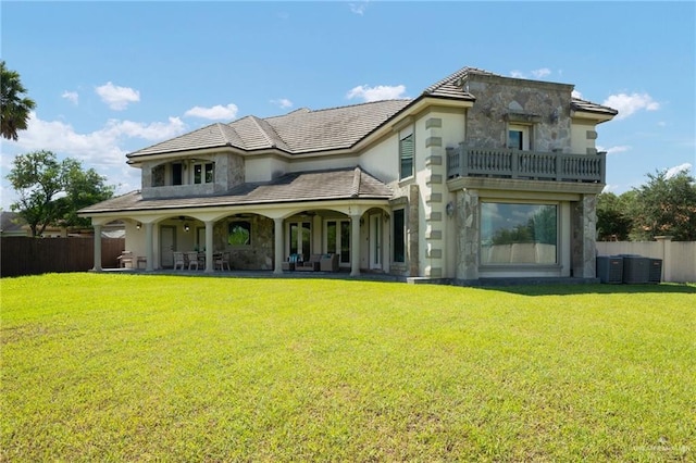 back of property featuring a yard and a balcony