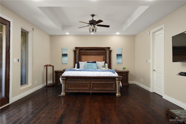 bedroom featuring dark hardwood / wood-style flooring, a raised ceiling, and ceiling fan