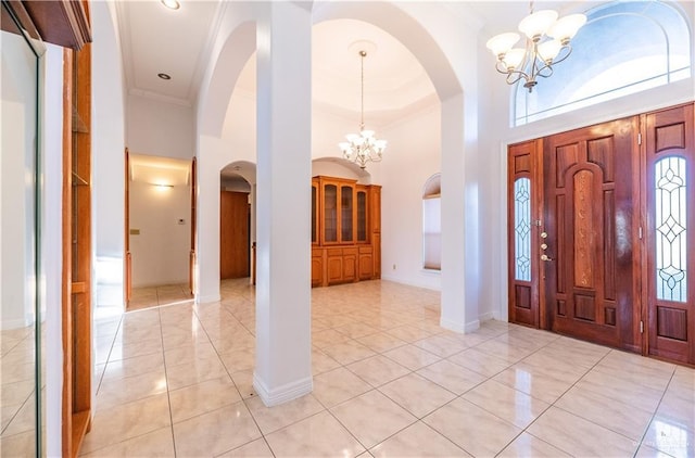 foyer entrance with an inviting chandelier, a high ceiling, and ornamental molding