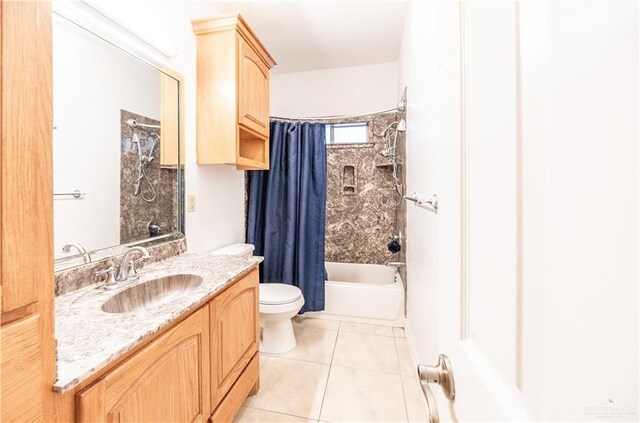 full bath with tile patterned floors, shower / bath combo with shower curtain, toilet, and vanity