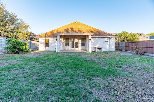 back of property featuring a lawn, french doors, a fenced backyard, and a patio