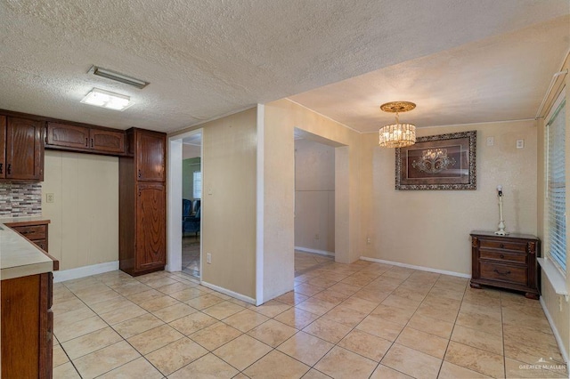 1106 17th St, Mcallen, TX 78501 - kitchen featuring light countertops, a chandelier, light tile patterned floors, a textured ceiling, and pendant lighting