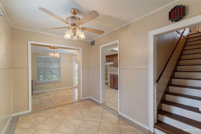 1106 17th St, Mcallen, TX 78501 - stairway with ceiling fan, wainscoting, crown molding, tile patterned flooring, and a chandelier