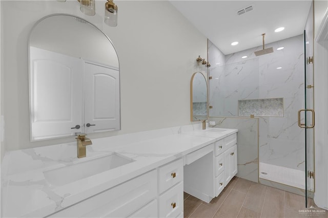 bathroom with a shower with door and vanity