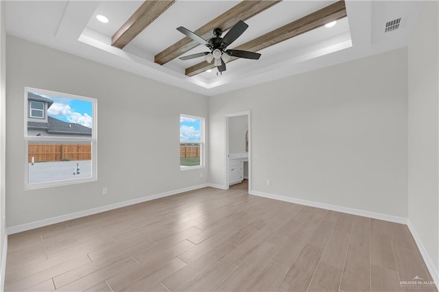 spare room with ceiling fan, light hardwood / wood-style floors, a raised ceiling, and beamed ceiling