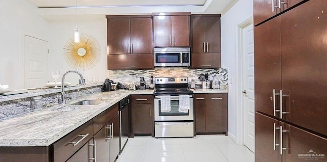 kitchen with sink, hanging light fixtures, light tile patterned floors, tasteful backsplash, and stainless steel appliances