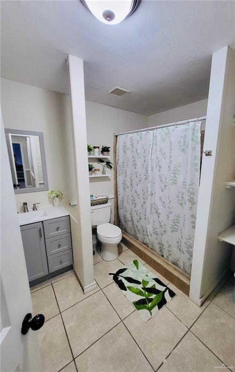 bathroom featuring tile patterned flooring, vanity, and toilet