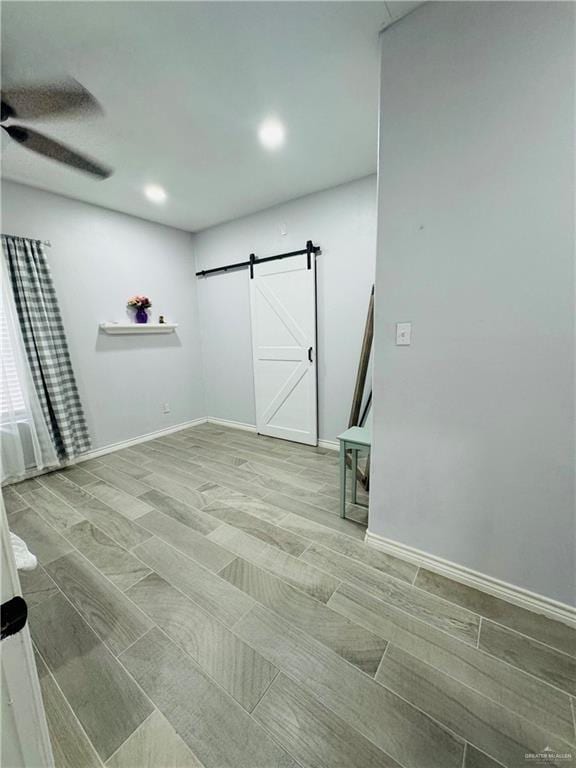 interior space featuring a barn door and ceiling fan