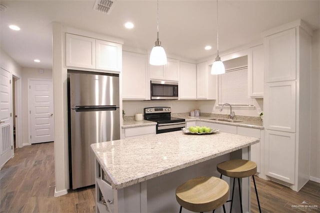 1909 Taft St, Weslaco, TX 78596 - kitchen featuring appliances with stainless steel finishes, a sink, a center island, white cabinets, and recessed lighting