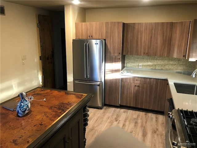 1316 W Maple Ave, Mcallen, TX 78501 - kitchen with stainless steel appliances, light wood-type flooring, light countertops, and brown cabinetry