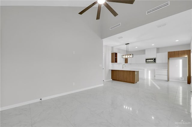 unfurnished living room with marble finish floor, baseboards, visible vents, and ceiling fan with notable chandelier