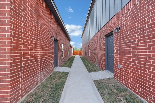 view of property exterior with brick siding and fence