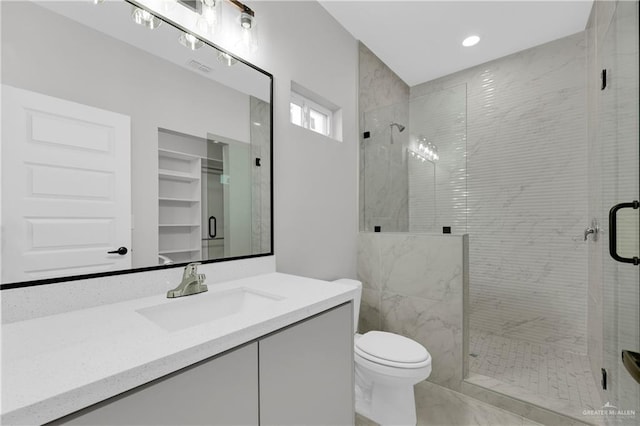 full bathroom featuring vanity, a shower stall, and toilet