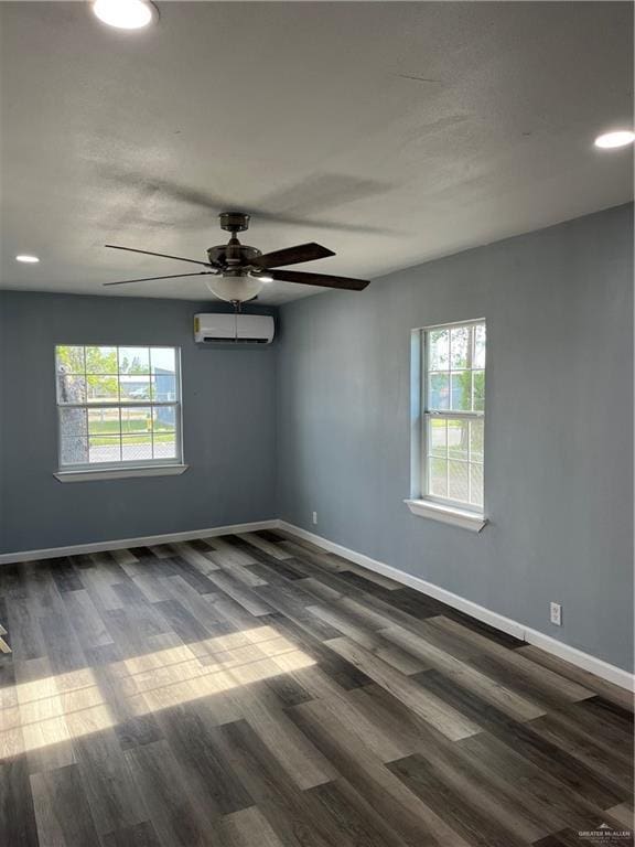 306 W 3rd St, San Juan, TX 78589 - empty room featuring baseboards, dark wood finished floors, ceiling fan, and a wall mounted AC