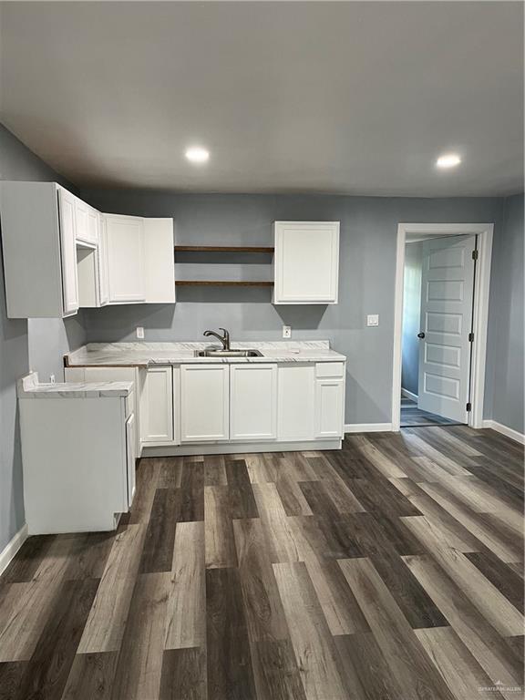 306 W 3rd St, San Juan, TX 78589 - kitchen with open shelves, a sink, recessed lighting, baseboards, and dark wood-style floors