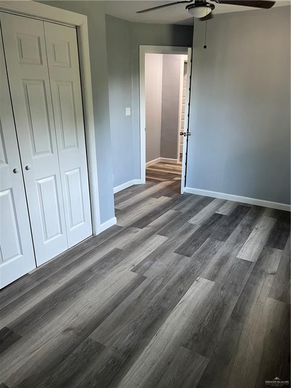 306 W 3rd St, San Juan, TX 78589 - unfurnished bedroom with baseboards, a ceiling fan, dark wood-style flooring, and a closet