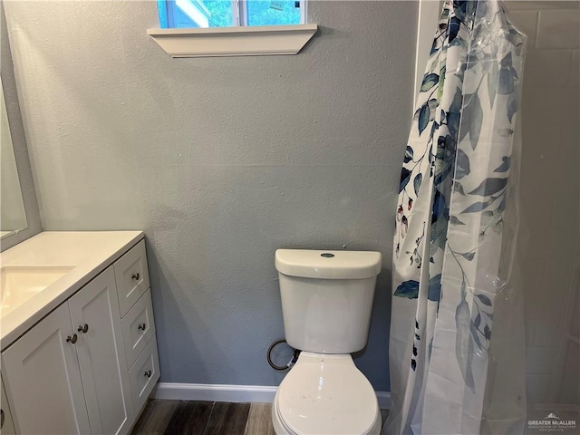 306 W 3rd St, San Juan, TX 78589 - bathroom featuring a shower with curtain, wood finished floors, vanity, baseboards, and toilet