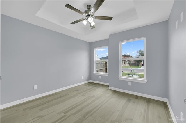 empty room with a tray ceiling and ceiling fan