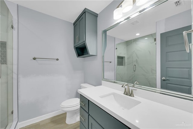 bathroom featuring vanity, hardwood / wood-style flooring, toilet, and walk in shower