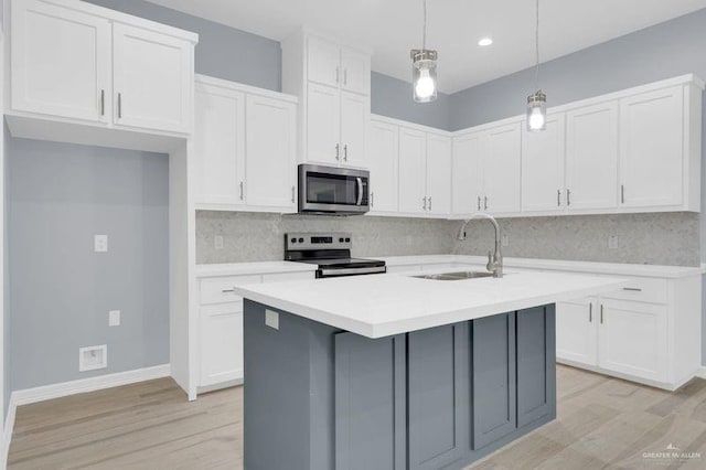 kitchen with white cabinetry, decorative light fixtures, and appliances with stainless steel finishes