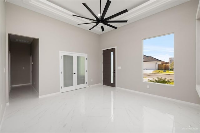 spare room featuring baseboards, ceiling fan, french doors, a high ceiling, and marble finish floor