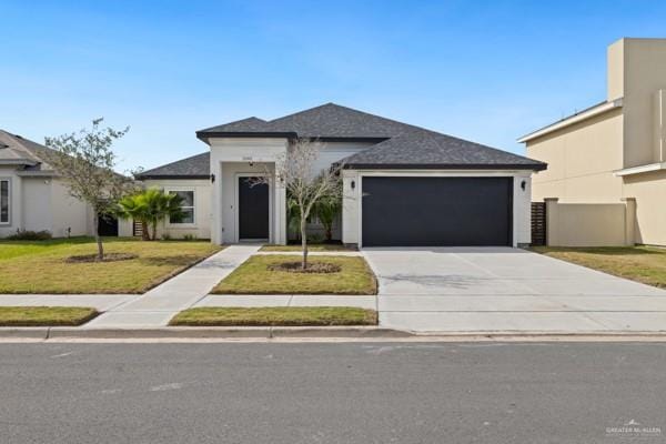 view of front of home with a garage and a front lawn