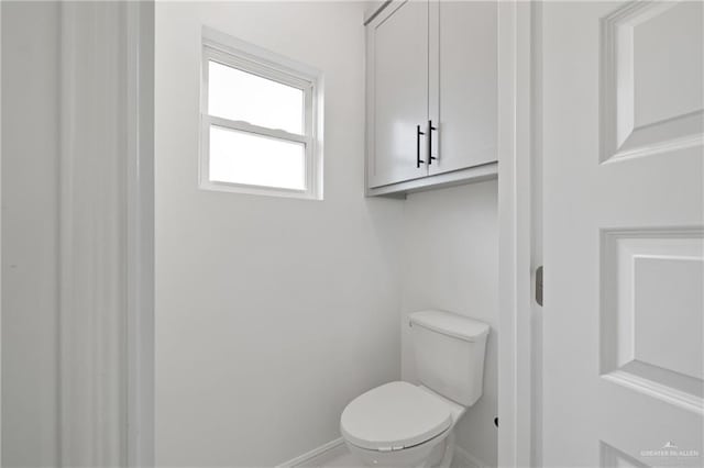 bathroom with baseboards and toilet