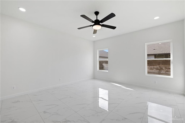 unfurnished room with a ceiling fan, recessed lighting, marble finish floor, and baseboards