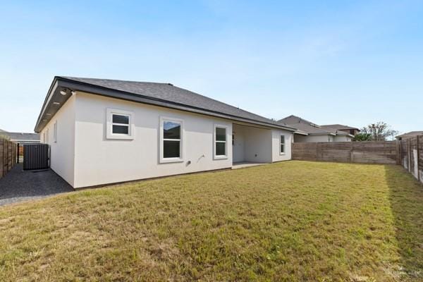 back of house with a yard and central AC