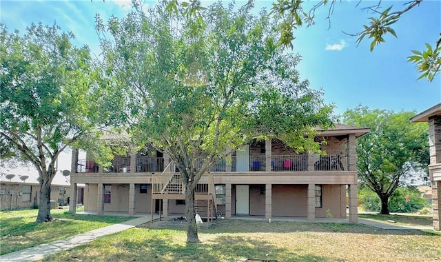 view of front of house featuring a patio area, a balcony, and a front yard
