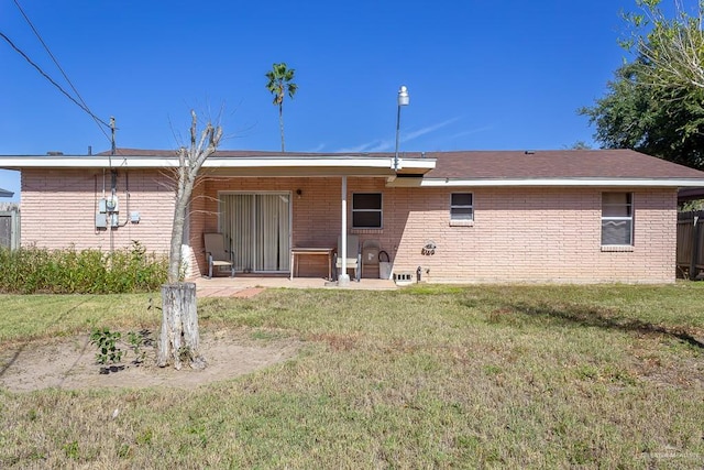 rear view of house featuring a patio area and a yard