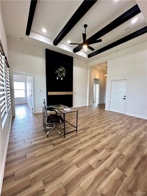 living room with ceiling fan and beamed ceiling