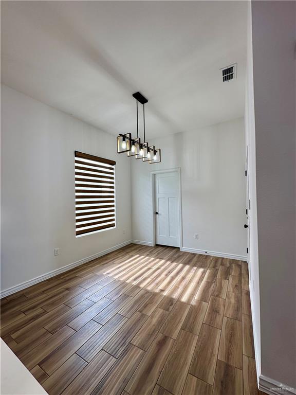 unfurnished dining area featuring a chandelier