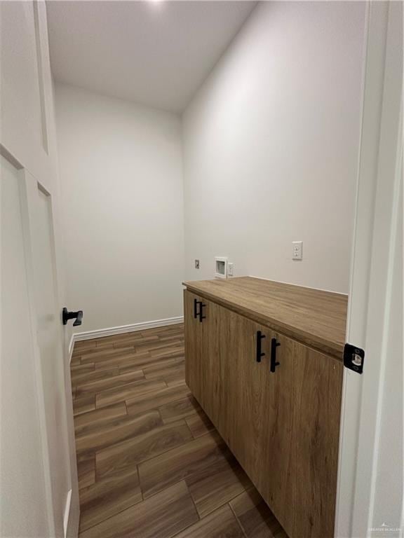 clothes washing area with dark wood-type flooring and washer hookup