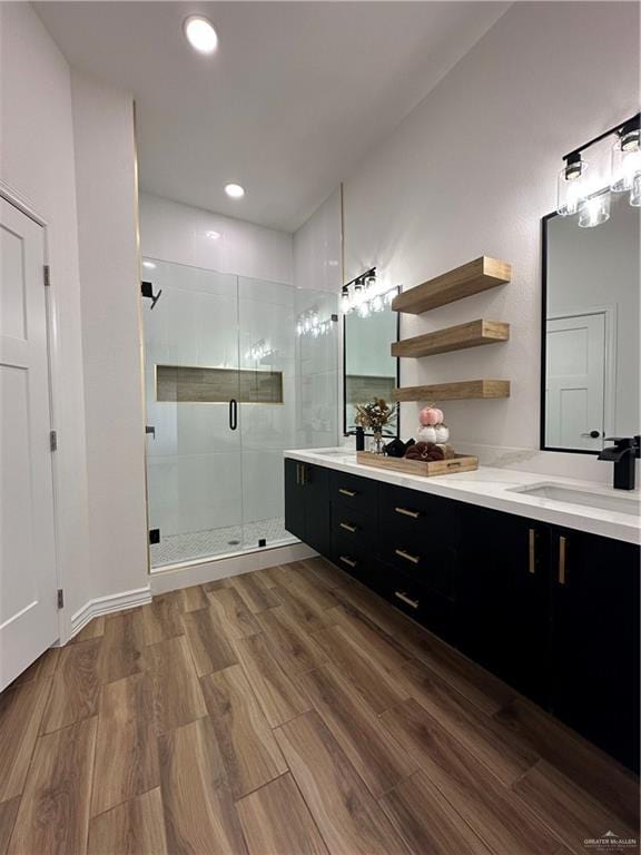 bathroom with a shower with shower door and vanity