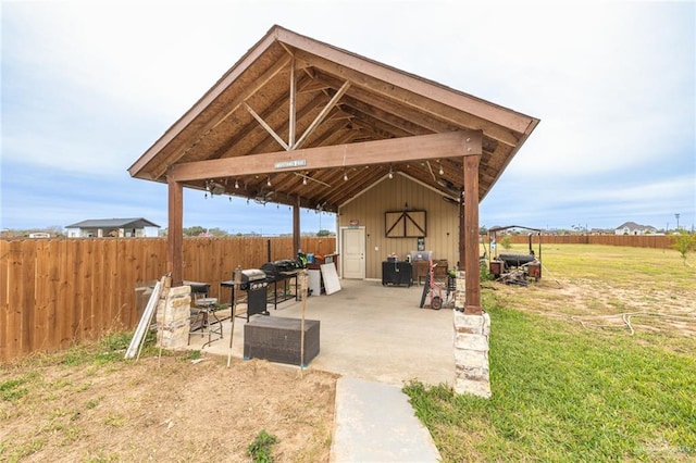 view of patio with a storage unit, an outdoor structure, and a fenced backyard