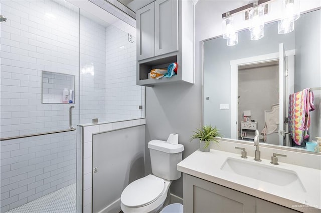 bathroom featuring toilet, a stall shower, and vanity