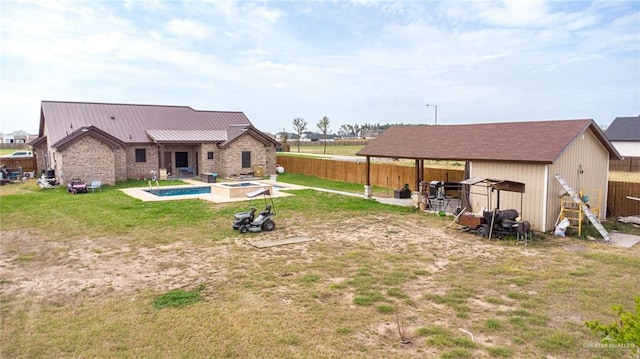 back of property featuring a fenced backyard, a pool with connected hot tub, and a lawn