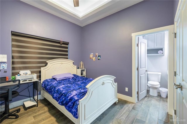 bedroom featuring ensuite bath, baseboards, ceiling fan, and dark wood-style flooring