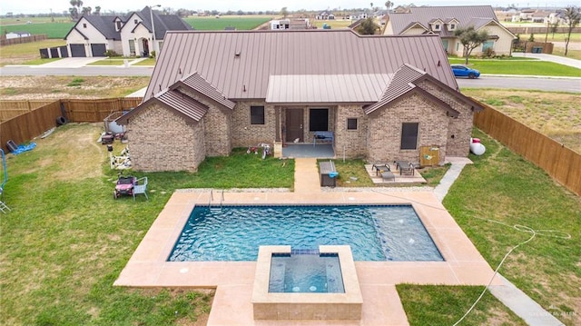 view of swimming pool with a patio, a yard, a fenced backyard, and a pool with connected hot tub