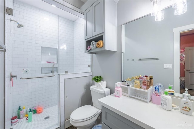 bathroom featuring toilet, a shower stall, and vanity