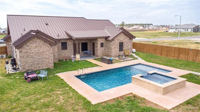 view of pool featuring fence private yard, a pool with connected hot tub, a lawn, and a patio