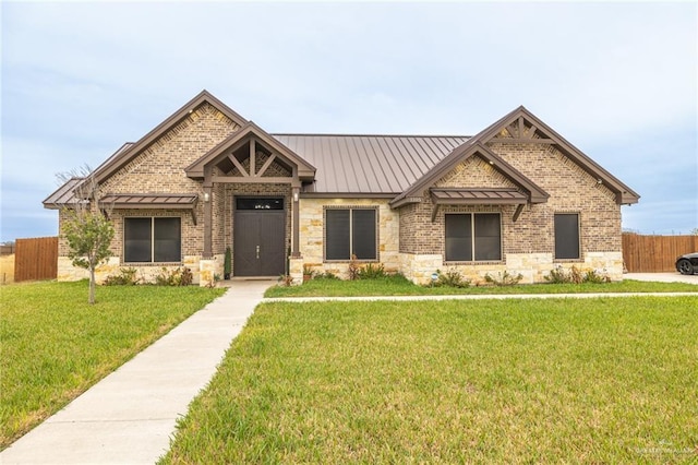 craftsman house featuring metal roof, a front lawn, a standing seam roof, and fence