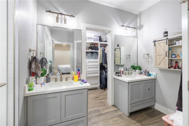 bathroom featuring wood tiled floor, two vanities, and a sink