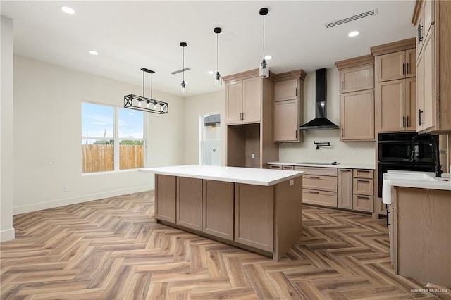 kitchen featuring pendant lighting, light parquet floors, wall chimney range hood, and a center island