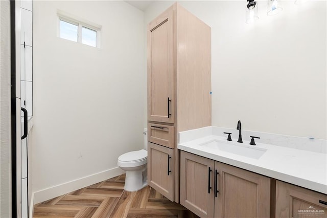 bathroom with toilet, parquet floors, and vanity