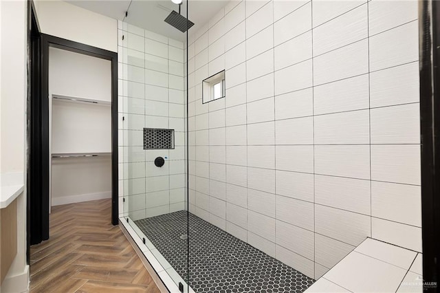 bathroom featuring parquet floors and a tile shower