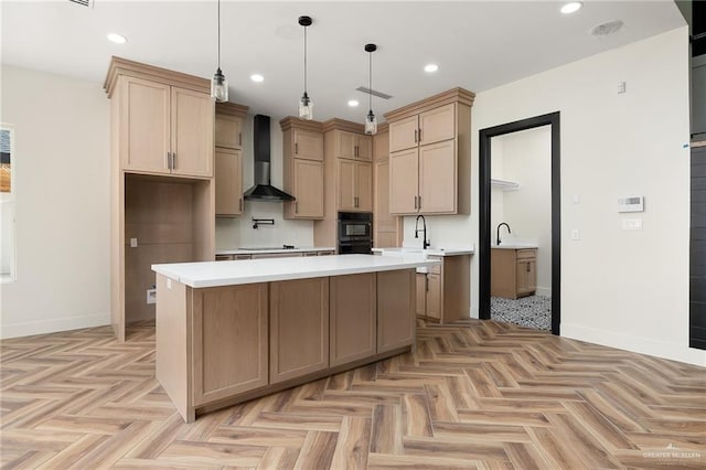 kitchen with light parquet flooring, wall chimney range hood, pendant lighting, black appliances, and a kitchen island