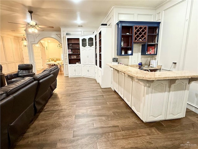 6101 Mile 7 Rd, Mission, TX 78573 - bar area with arched walkways, dark wood-style flooring, a ceiling fan, a decorative wall, and crown molding