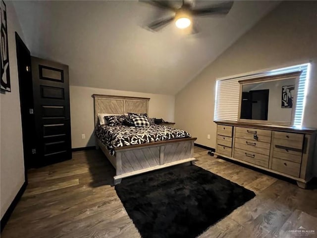 bedroom featuring dark hardwood / wood-style flooring, vaulted ceiling, and ceiling fan